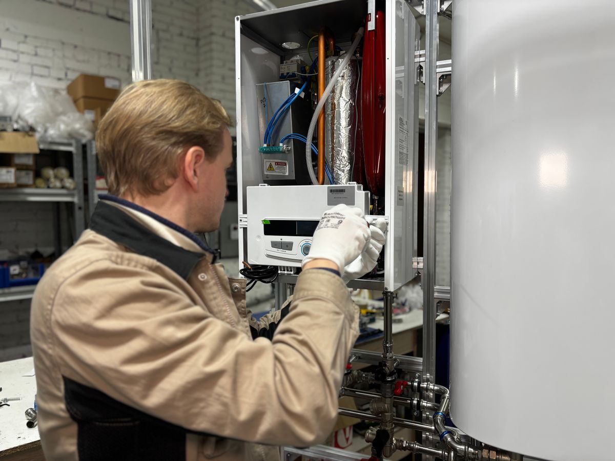 Technician servicing a home boiler and water heater unit