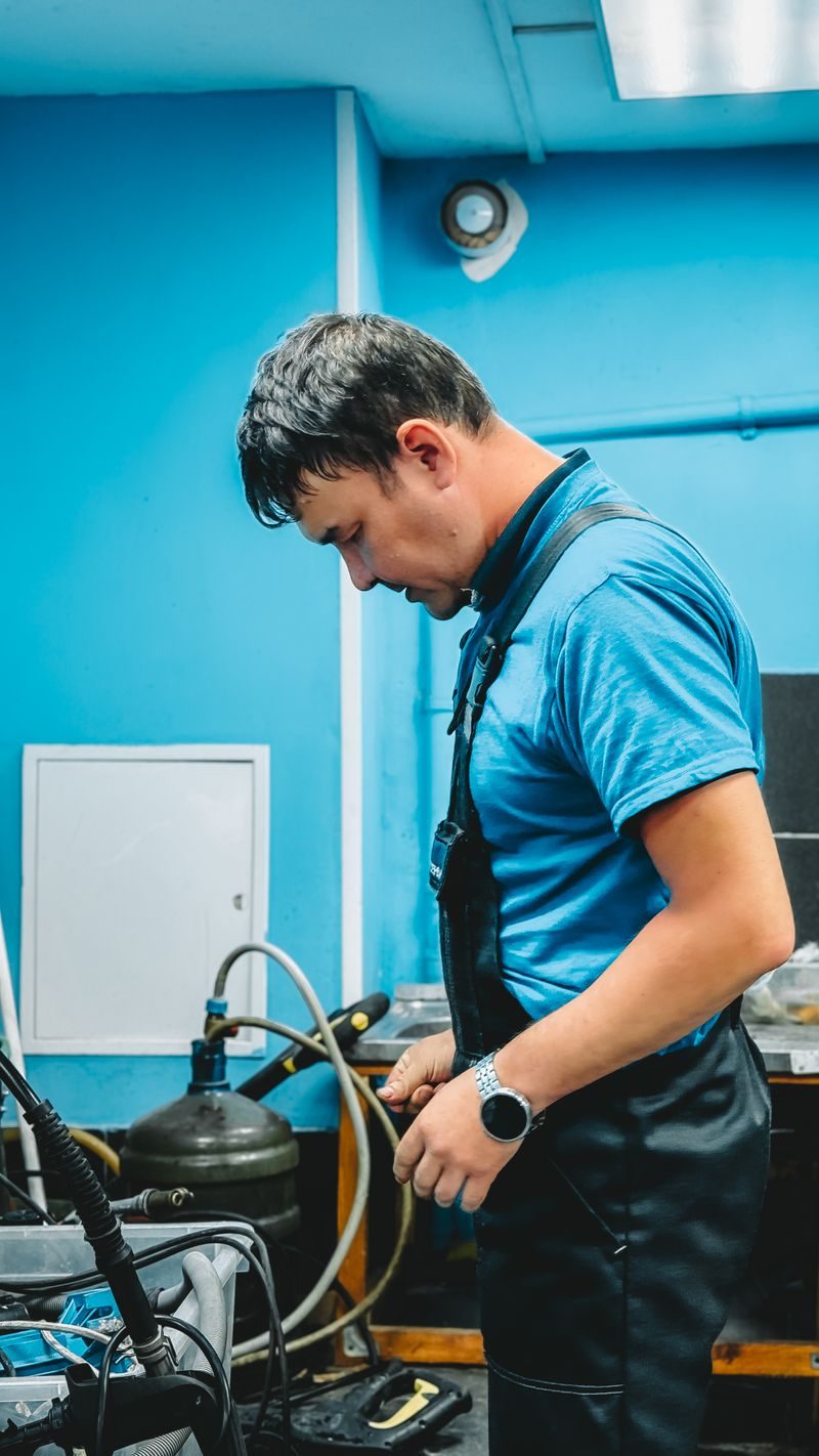 FlowRight plumber servicing a water heater with gauges