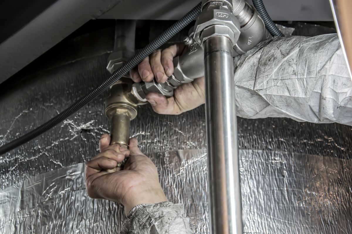 Plumber hands fitting steel pipes