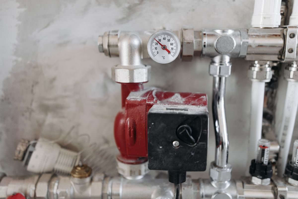 Industrial pump room with red valves and pressure gauges